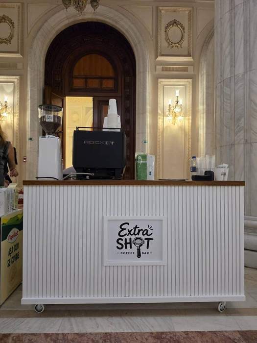 Bar de cafea montat într-o sală elegantă de palat, cu coloane și lumini de cristal